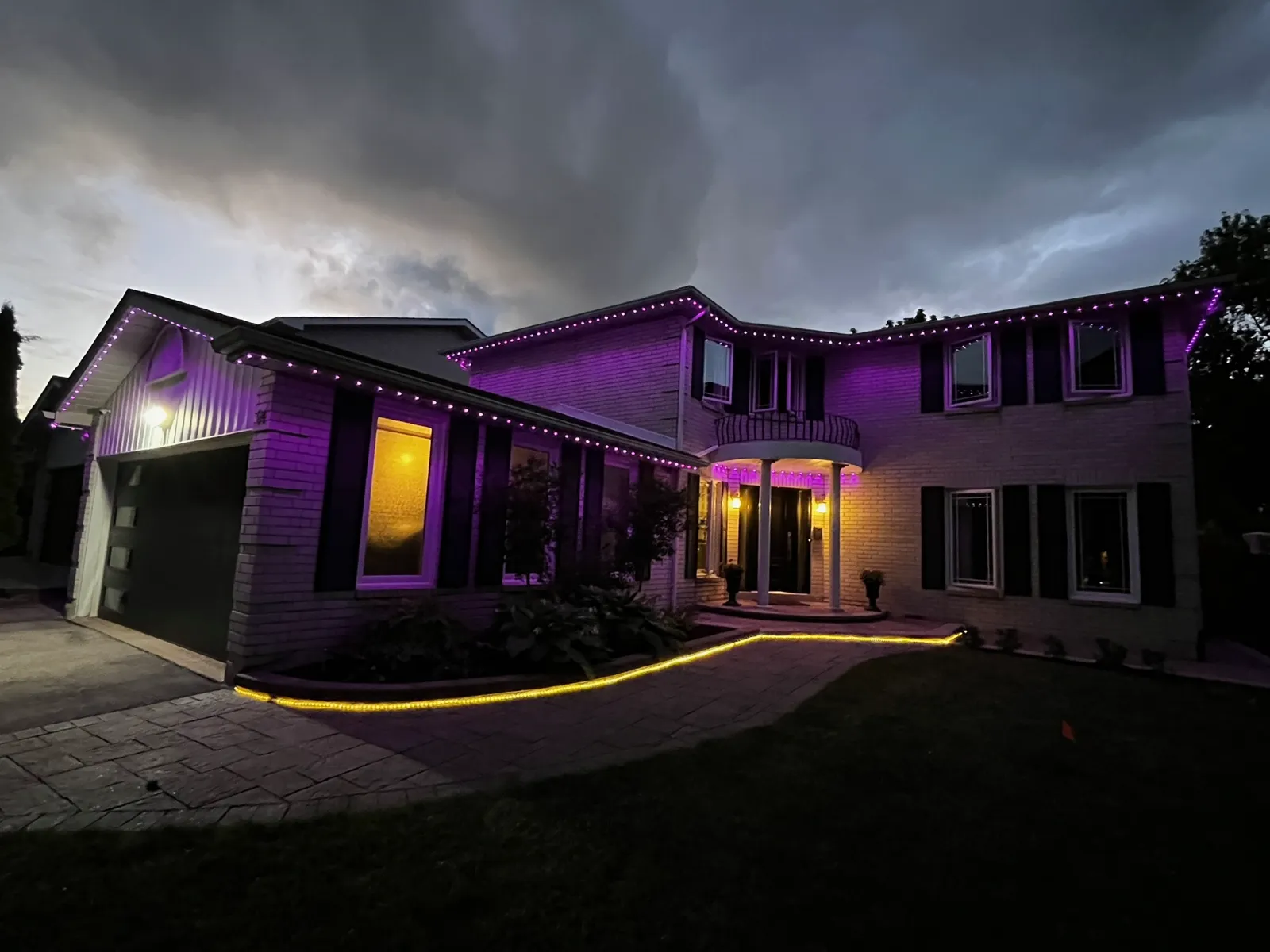Home with purple permanent LED roofline lighting at dusk