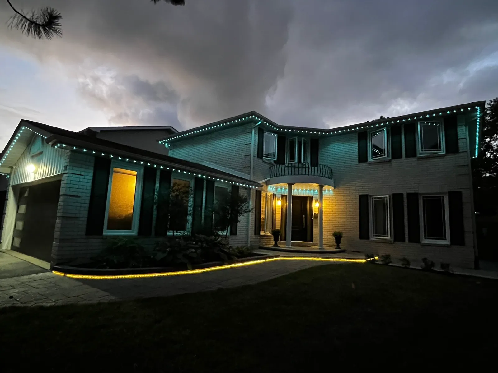 Home with pink permanent LED roofline lighting at dusk
