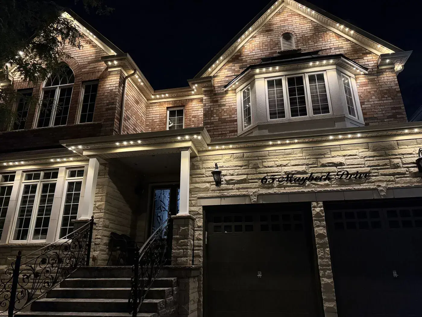 Stone home with warm white permanent LED soffit lighting