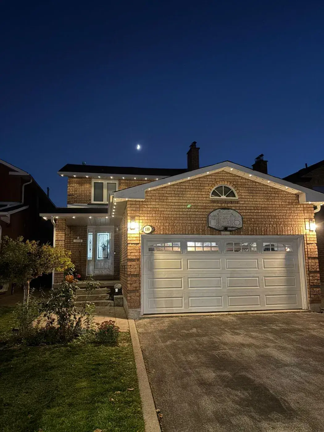 Home with warm white permanent LED roofline lighting at dusk