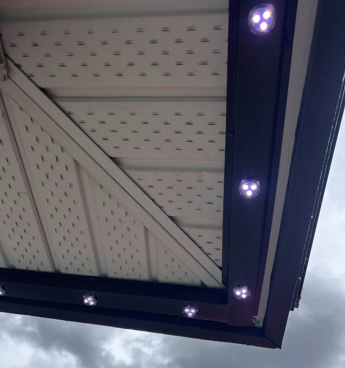 Close-up of illuminated Prairie Lighting LED pixels installed in aluminum track beneath a home's roofline