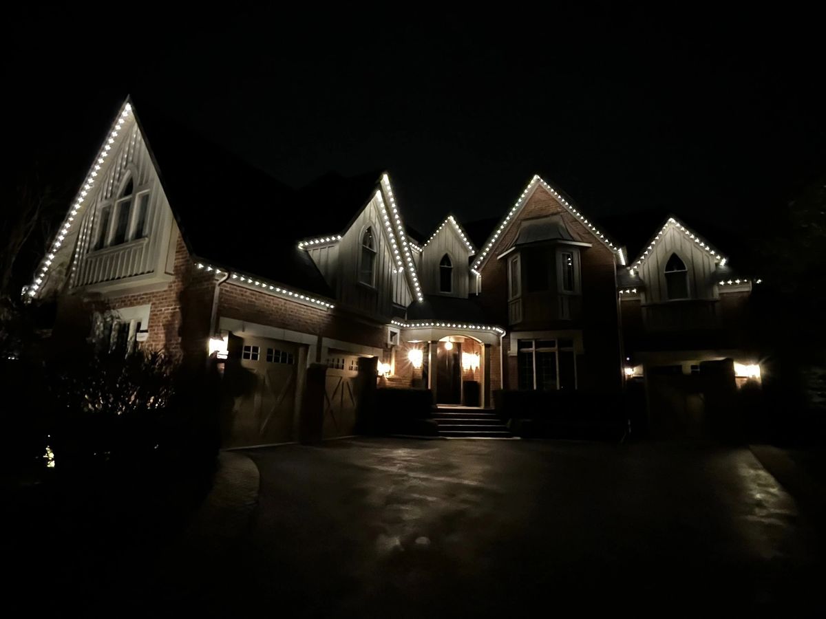 Vancouver home with cool white permanent LED roofline lighting at night