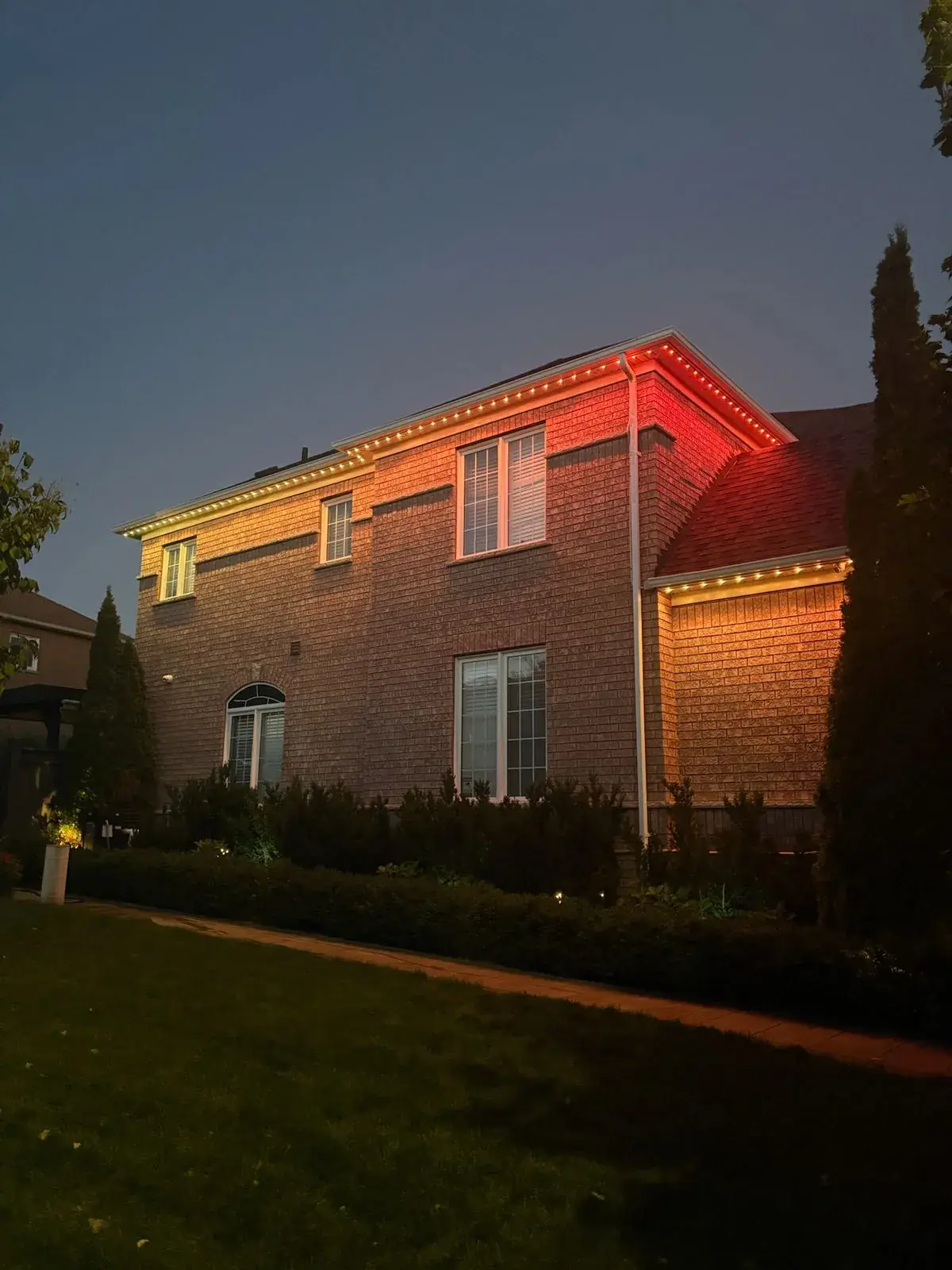 Vancouver home with red permanent LED roofline accent lighting at night