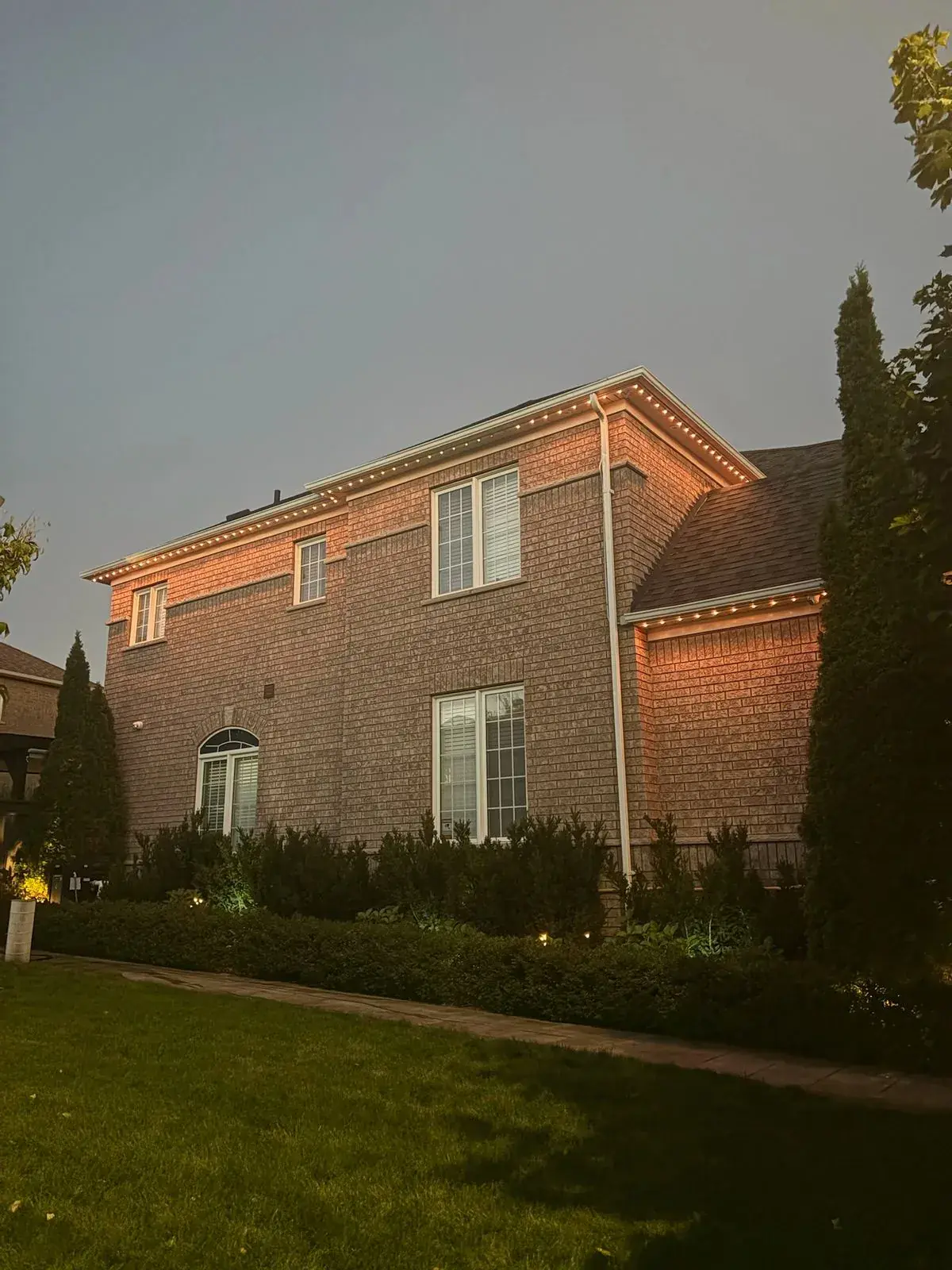 Vancouver home with warm amber permanent LED soffit lighting at dusk